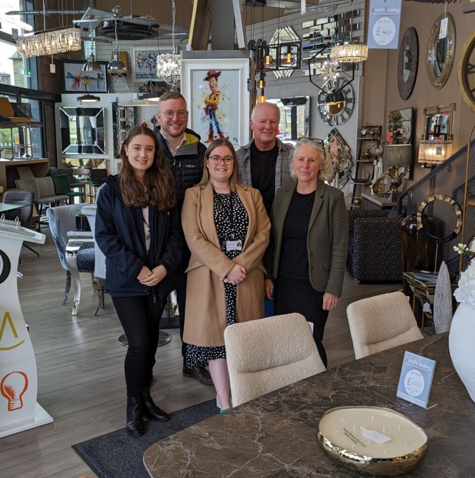three women and two men stood in a group inside a home furnishing shop