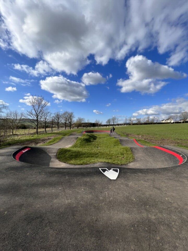 picture with blue skies and fluffy clouds and a new cycle and skate board track